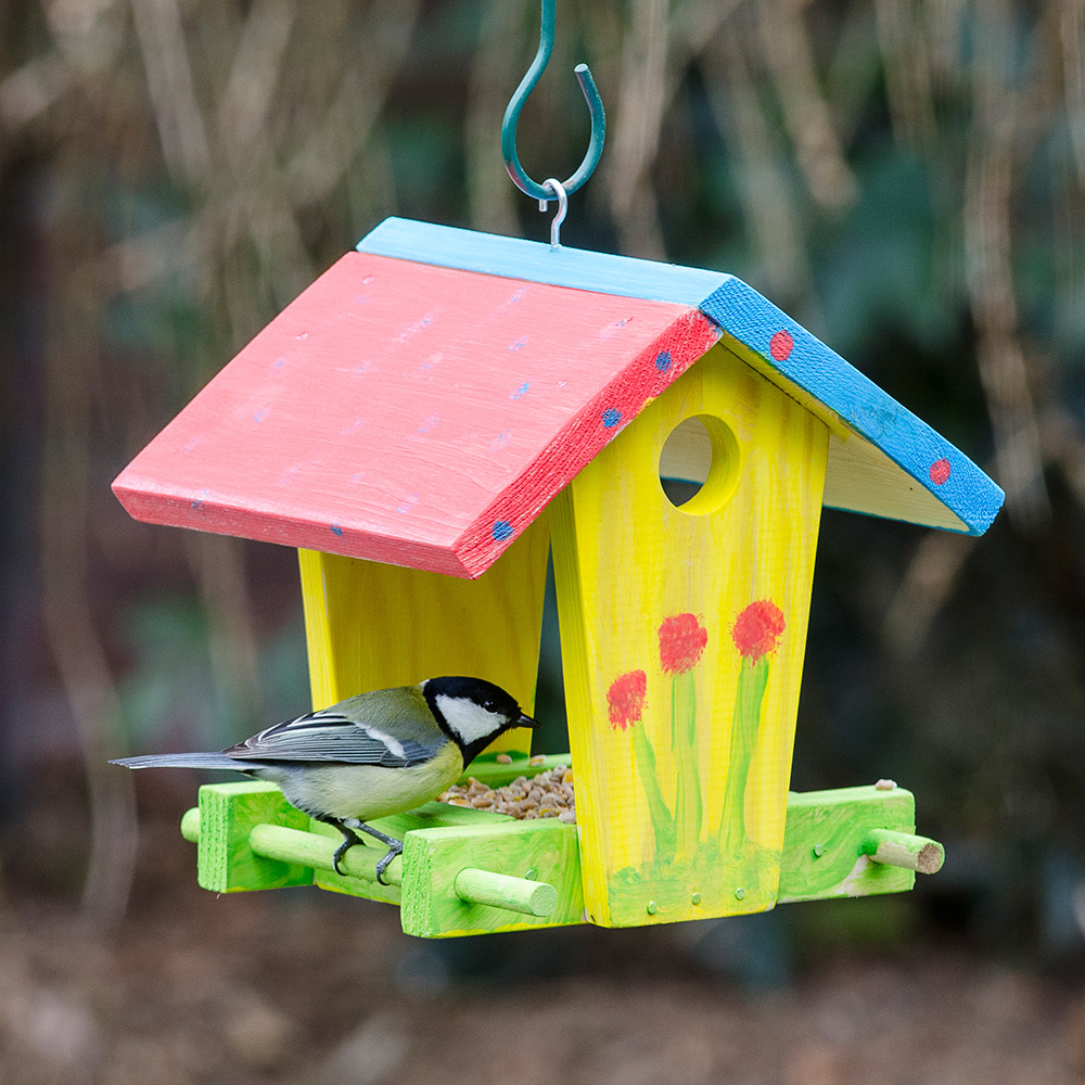 Ein farbenfroh bemaltes Vogelhäuschen.
