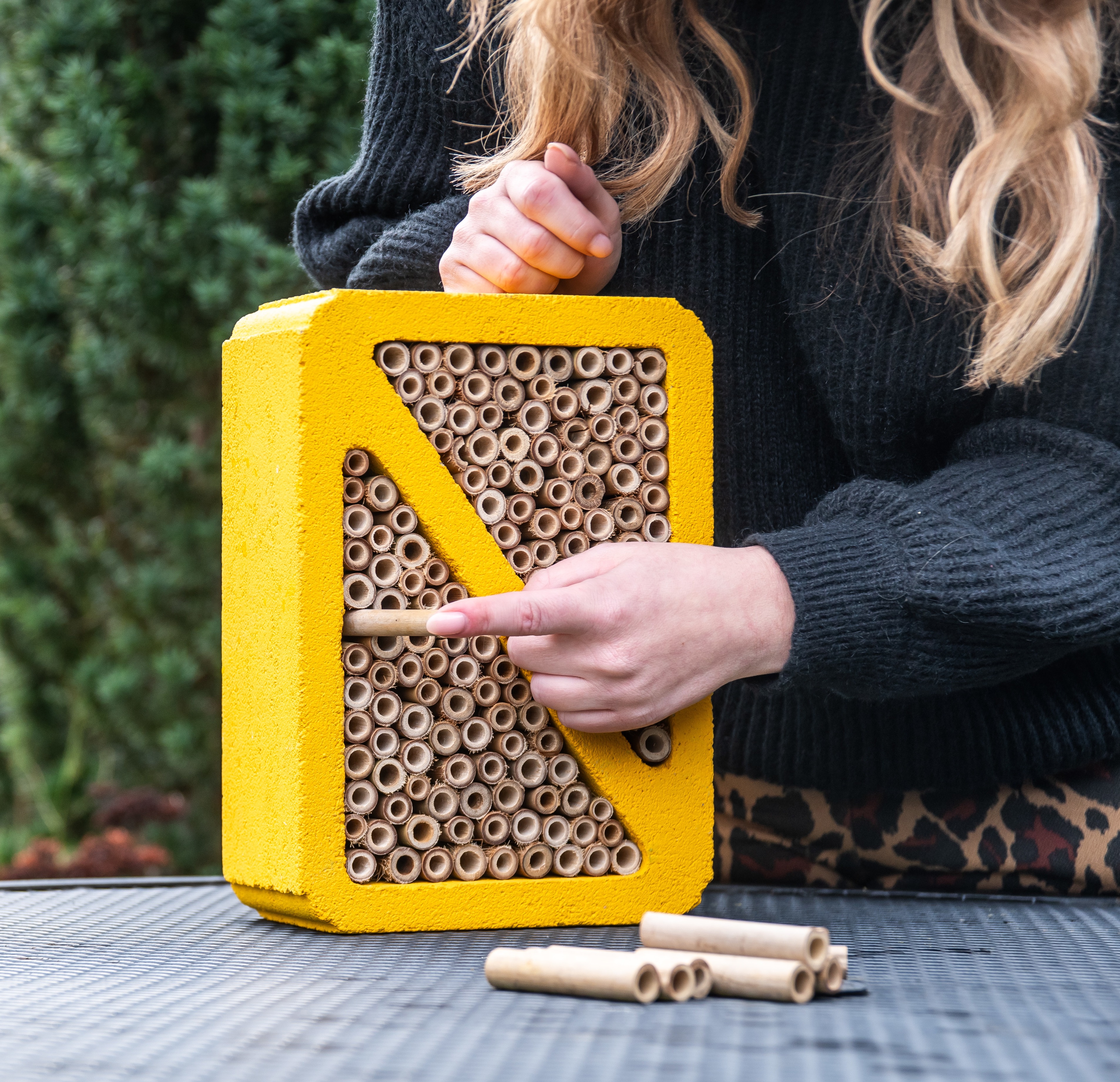 Child smiles while presenting the assembled nest box building kit